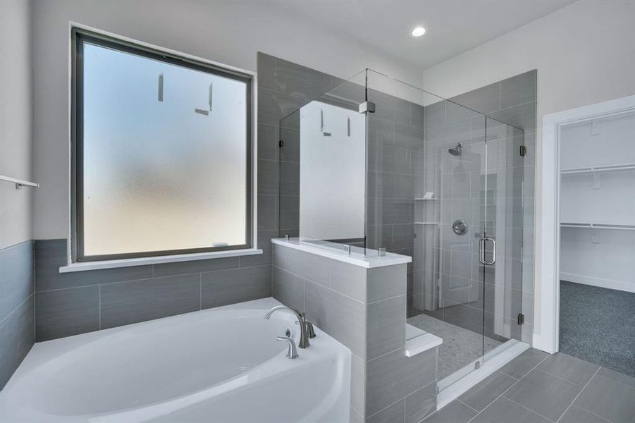 Bathroom featuring tile patterned flooring and shower with separate bathtub