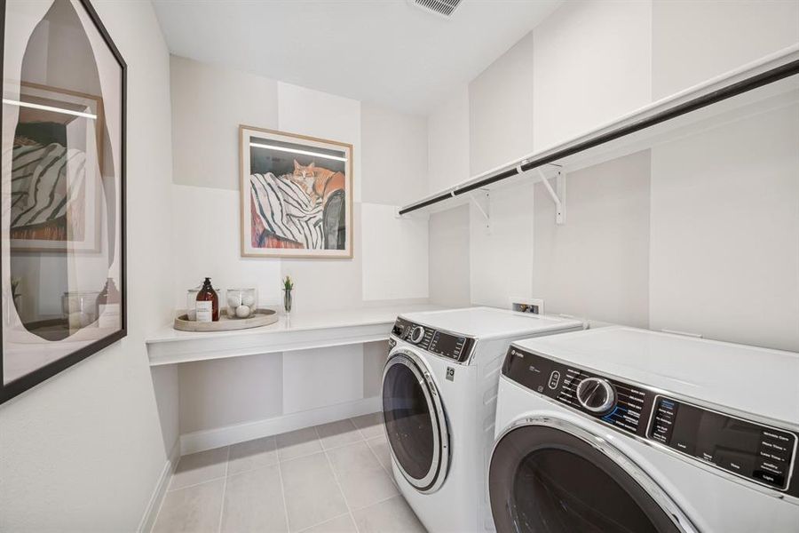 Laundry room with tile flooring, a built-in counter, and upper shelving