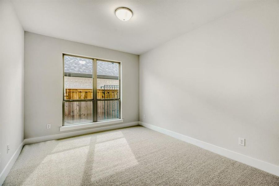 Spare room featuring carpet and baseboards