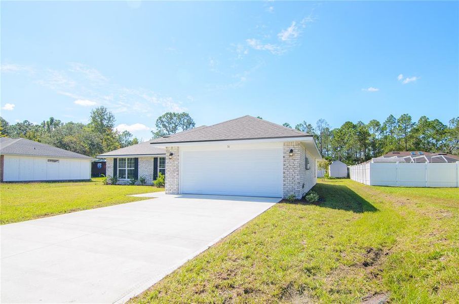 Front exterior of a new home in Palm Coast, Palm Coast, FL, highlighting curb appeal (Image 1). Front exterior of a new home in Palm Coast, Palm Coast, FL, highlighting curb appeal (Image 1).