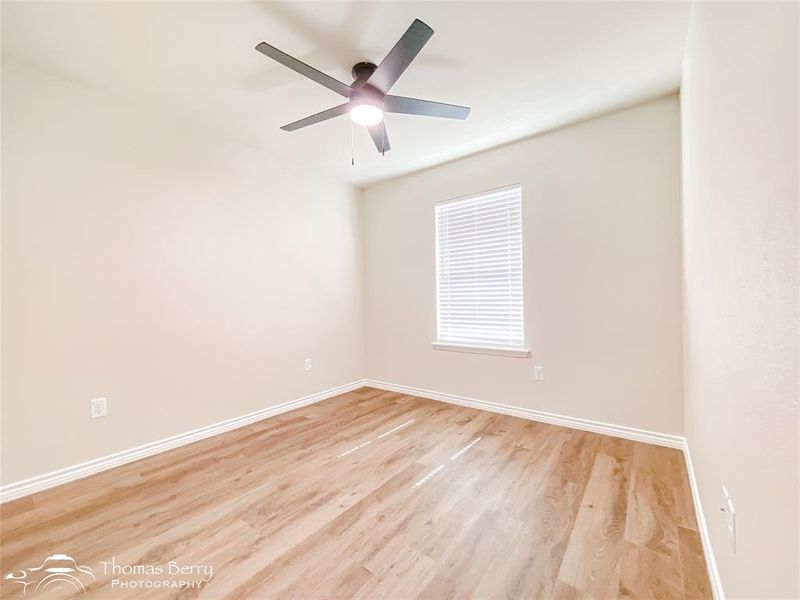 Unfurnished room with light wood finished floors and a ceiling fan Unfurnished room with light wood finished floors and a ceiling fan