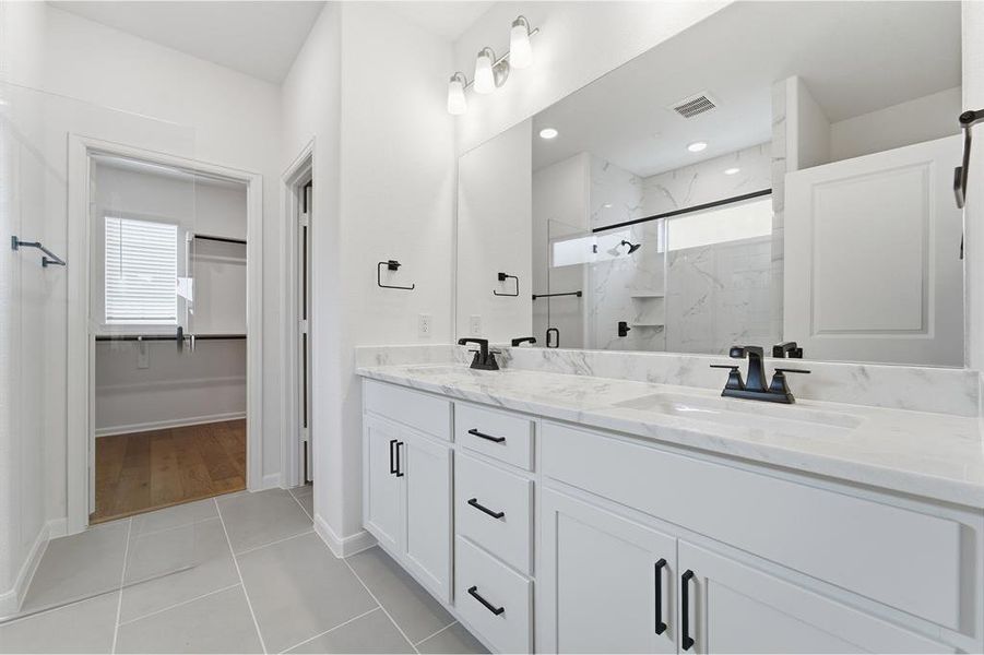 Dual vanity with undermount sinks, stone countertops, and matte black hardware