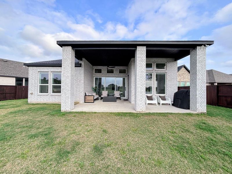 Spacious backyard with a well-maintained lawn and a covered patio area.