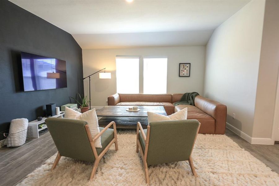 Living room featuring lofted ceiling and tile floors