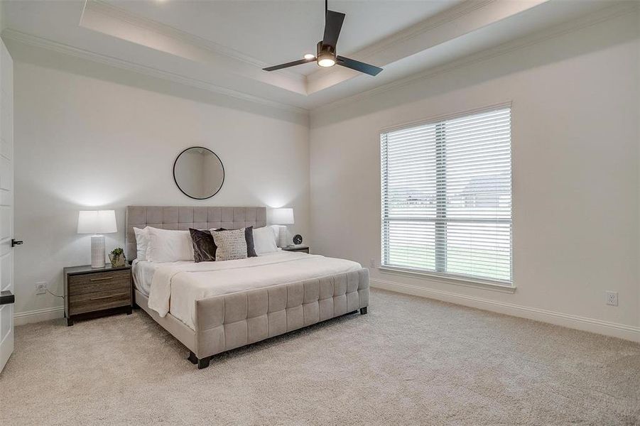 Primary bedroom with high ceilings and ceiling fan.