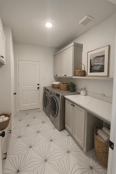 Laundry area with washer and clothes dryer, cabinet space, and light flooring