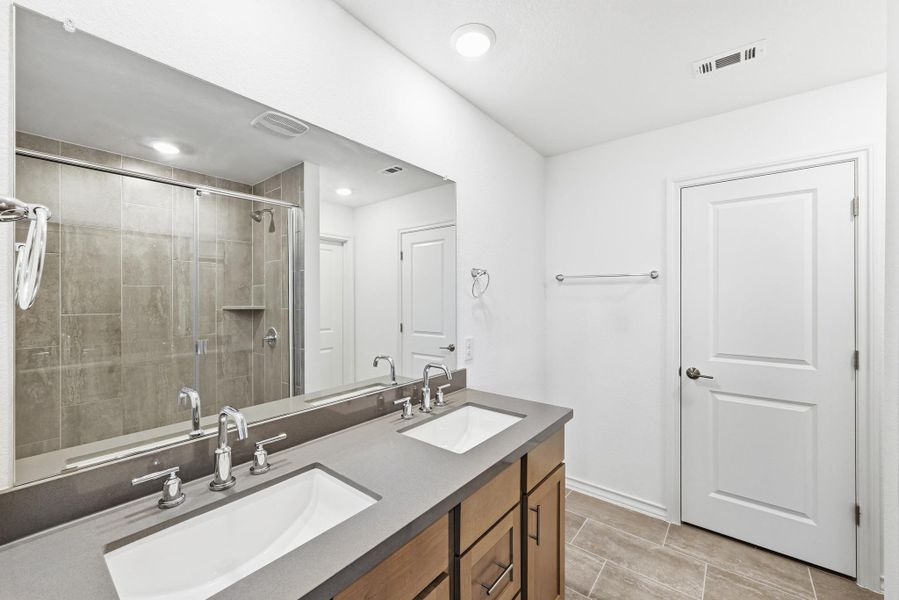 Full bath with double vanity, a stall shower, and wood tiled floors