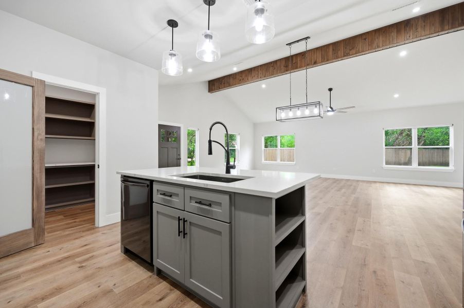 A contemporary kitchen island and open floorplan create a seamless flow into the sun-drenched living area. A contemporary kitchen island and open floorplan create a seamless flow into the sun-drenched living area.