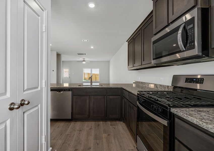 The kitchen looks out into the dining room and living room. The kitchen looks out into the dining room and living room.