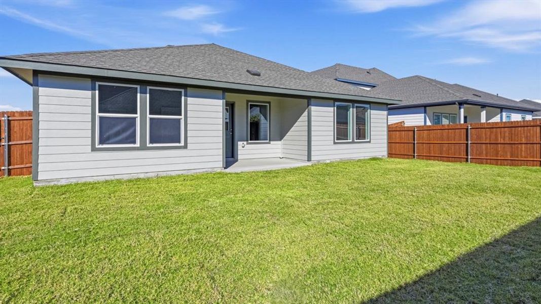 Back of property with a fenced backyard, a patio, and a shingled roof Back of property with a fenced backyard, a patio, and a shingled roof