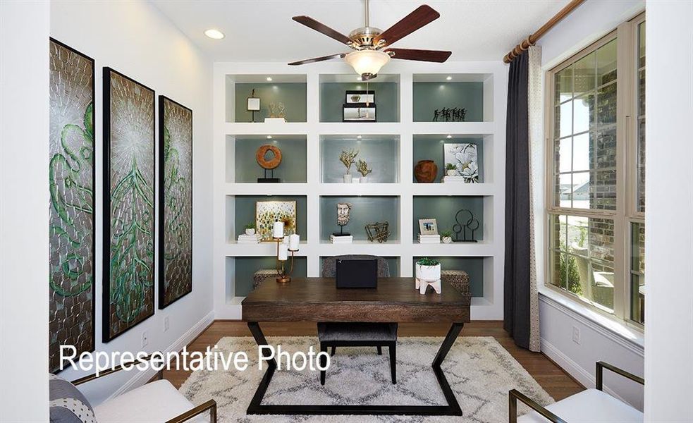 Built-in shelving with recessed lighting, wood-finish flooring, ceiling fan with integrated lighting, and a large multi-pane window Built-in shelving with recessed lighting, wood-finish flooring, ceiling fan with integrated lighting, and a large multi-pane window
