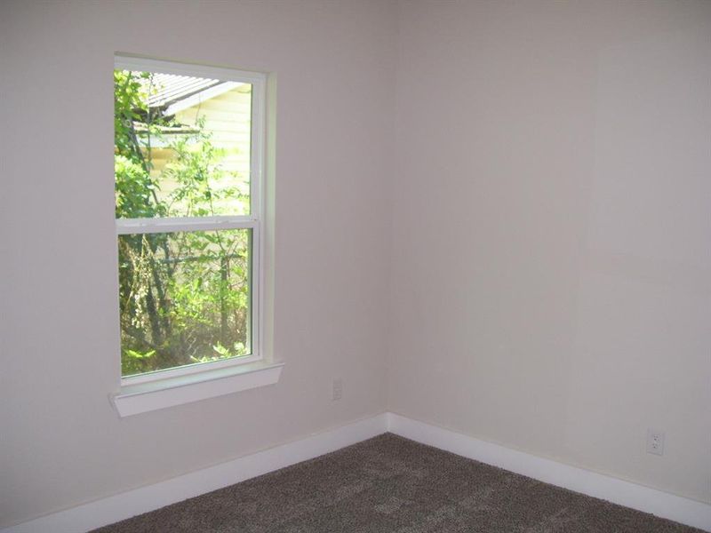 Spare room with dark colored carpet and plenty of natural light
