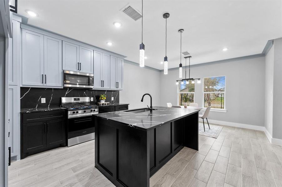 Enjoy a chef-inspired kitchen featuring stainless steel appliances, a spacious island, and modern finishes for your culinary needs.