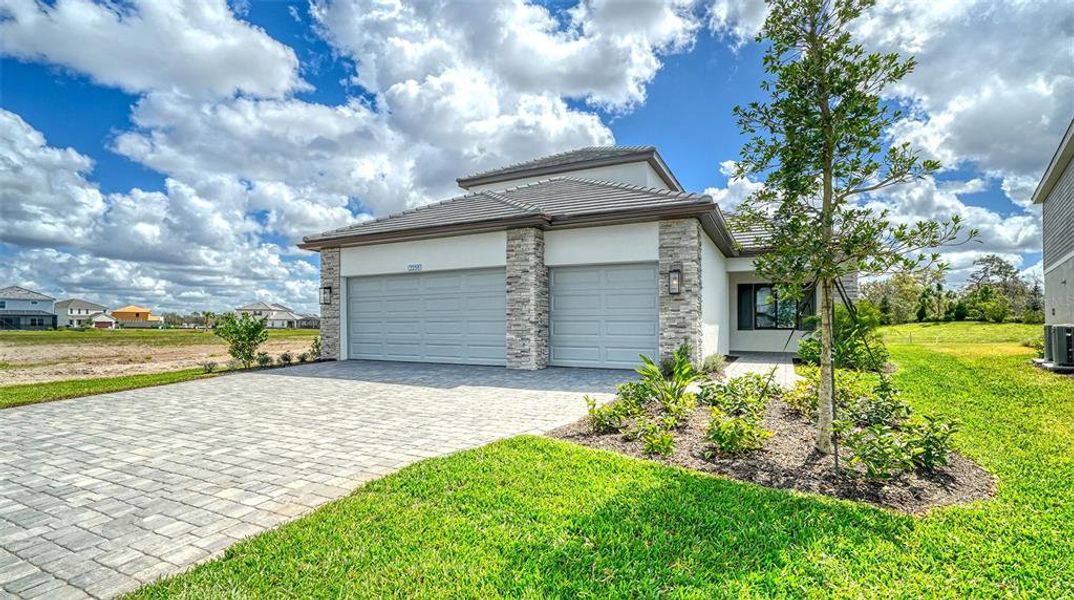 Front exterior of a new home in Palm Grove, Lakewood Ranch, FL, highlighting curb appeal (Image 22).