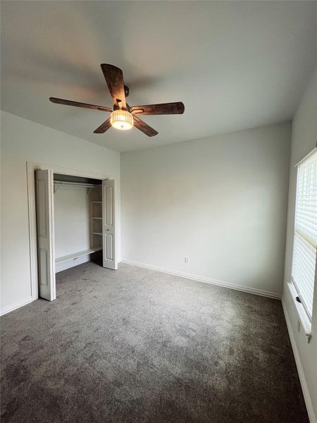 Unfurnished bedroom with ceiling fan, baseboards, a closet, and carpet Unfurnished bedroom with ceiling fan, baseboards, a closet, and carpet