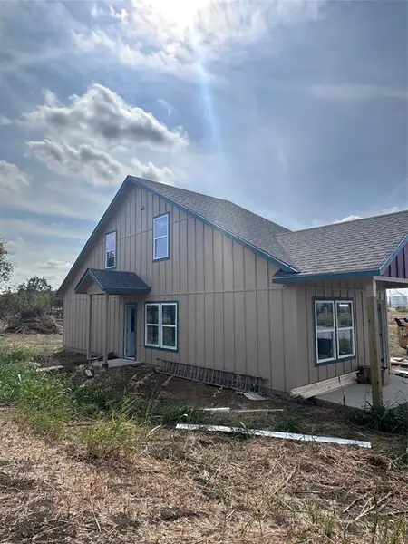 View of side of home with roof with shingles and board and batten siding