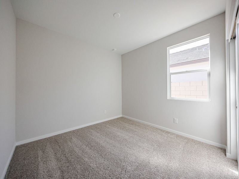 A room with a carpet and a window.