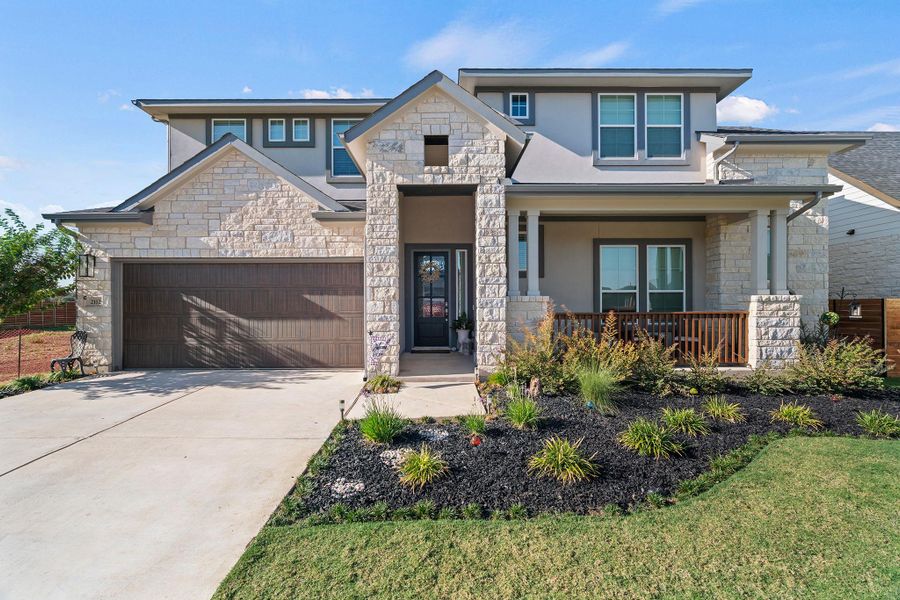 View of front facade featuring stone siding, stucco siding, driveway, and covered porch View of front facade featuring stone siding, stucco siding, driveway, and covered porch