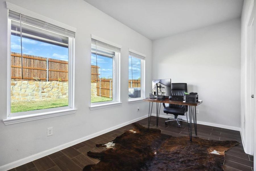 Office space featuring a wealth of natural light and dark hardwood / wood-style flooring