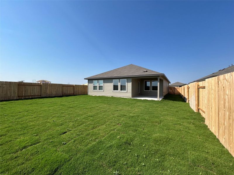 Rear view of house with a patio, a fenced backyard, and a shingled roof Rear view of house with a patio, a fenced backyard, and a shingled roof