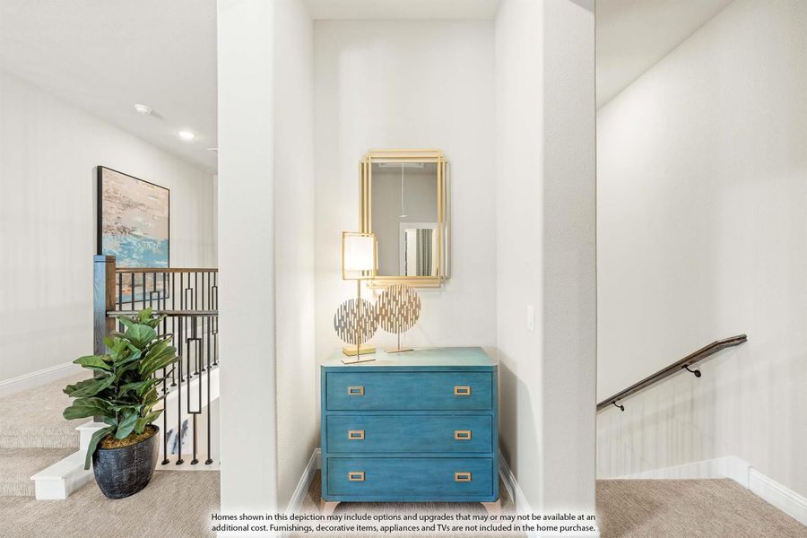 Upstairs hallway landing with teal dresser, gold mirror, and staircase railing with carpet flooring Upstairs hallway landing with teal dresser, gold mirror, and staircase railing with carpet flooring