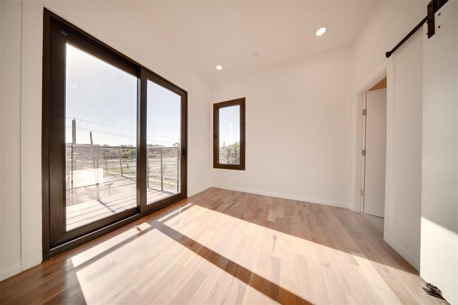 Empty room with light hardwood / wood-style flooring and a barn door