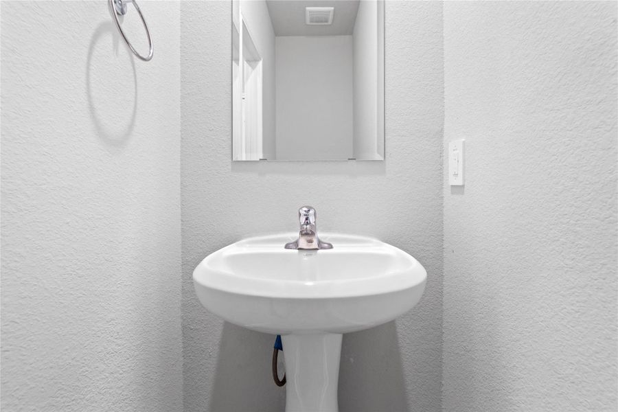 The powder bath features a stylish vanity and a clean, modern design.