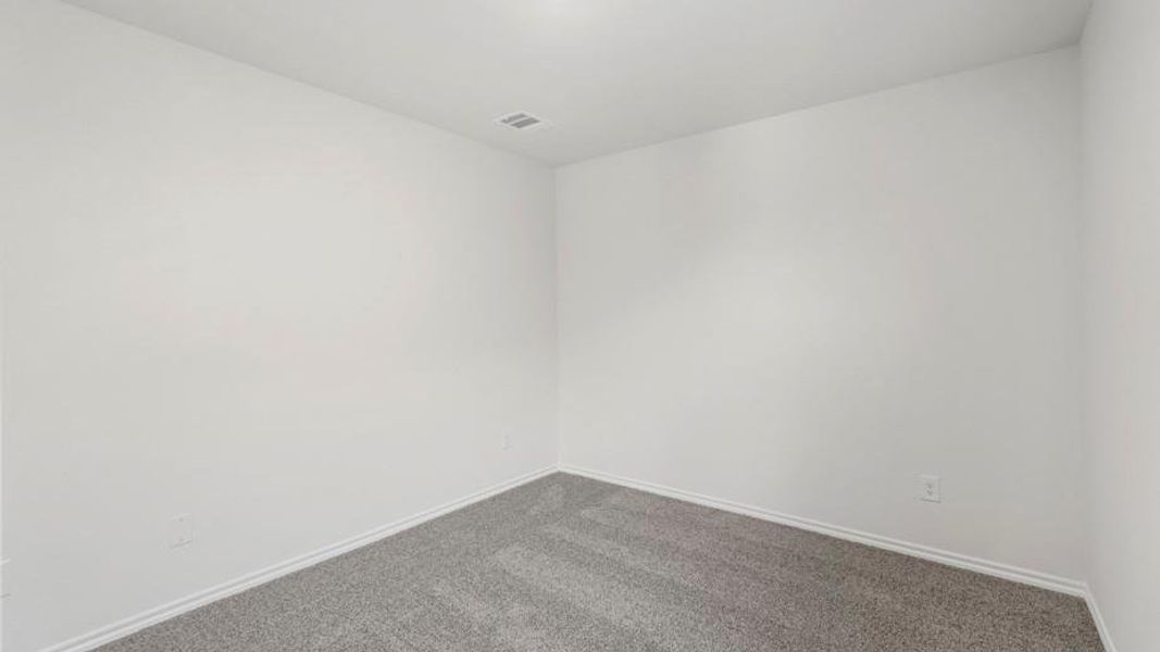 Spacious room featuring neutral carpeting, white wall paint, white baseboards, and a ceiling-mounted light fixture Spacious room featuring neutral carpeting, white wall paint, white baseboards, and a ceiling-mounted light fixture