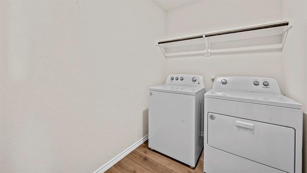 Laundry room featuring light wood-style flooring and independent washer and dryer