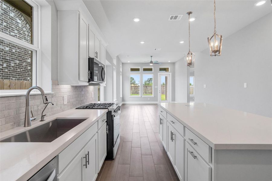 Welcome to the heart of the home, a modern, highly functional kitchen that perfectly balances style and utility. Quartz countertops, complemented by a stylish backsplash, cabinets that provide ample storage, under cabinet lighting, large single stainless steel undermount sink, and the Whirlpool stainless steel appliances are all features of this beautiful kitchen!
