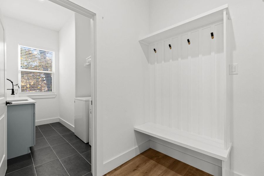 Mudroom featuring dark tile patterned flooring and washing machine and dryer