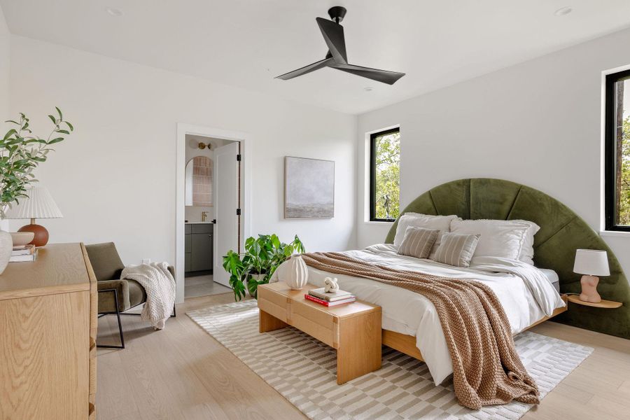 Bedroom with light wood-type flooring, ensuite bathroom, and a ceiling fan Bedroom with light wood-type flooring, ensuite bathroom, and a ceiling fan