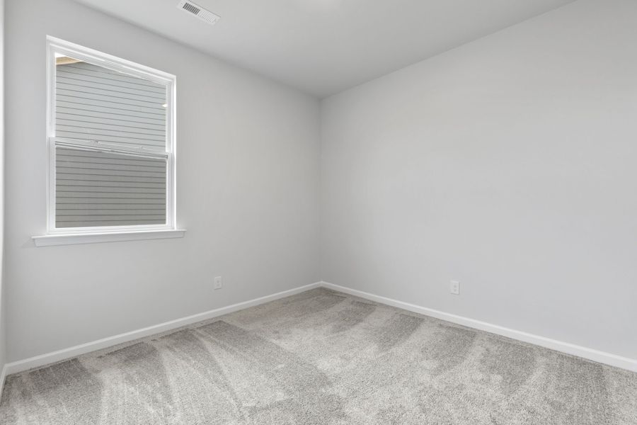 A room with a window and a carpet.