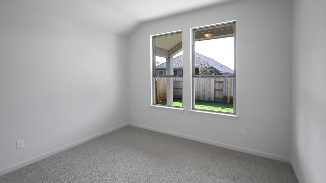 Carpeted empty room with baseboards and vaulted ceiling