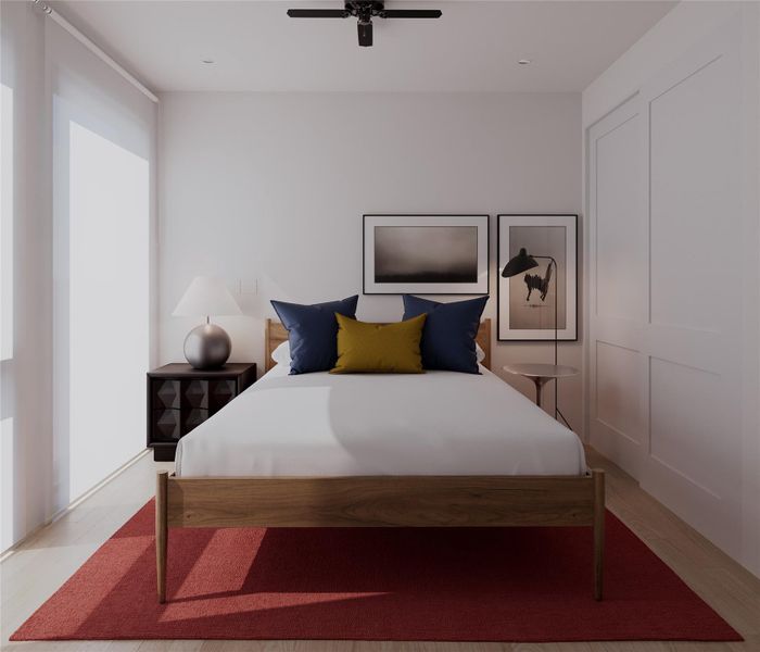 Bedroom with a ceiling fan and light wood-style flooring Bedroom with a ceiling fan and light wood-style flooring