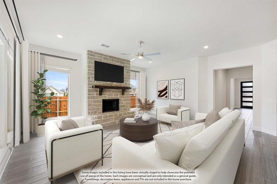 Living room with stone fireplace, wall-mounted TV, ceiling fan, and white seating on wood-look floors Living room with stone fireplace, wall-mounted TV, ceiling fan, and white seating on wood-look floors