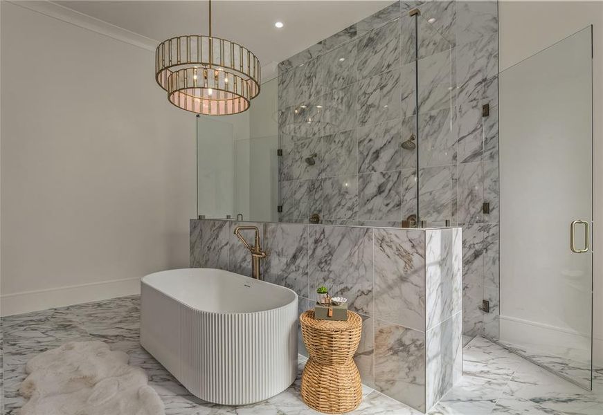 Freestanding soaking tub with vertical fluting and a floor-mounted brass faucet