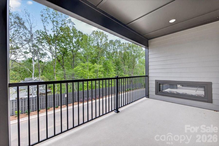 Covered outdoor living space with tree-lined views