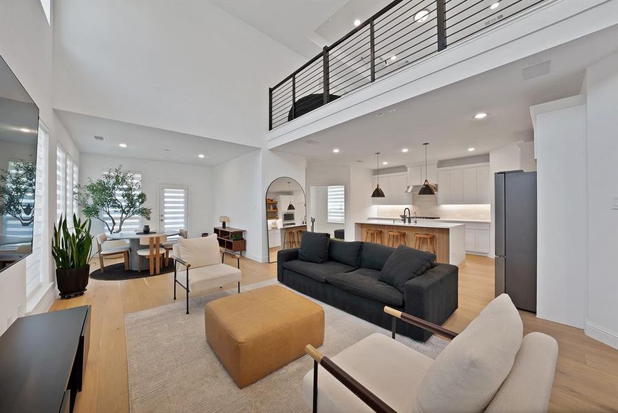Expansive open-concept living space featuring high ceilings and light wood-finish flooring