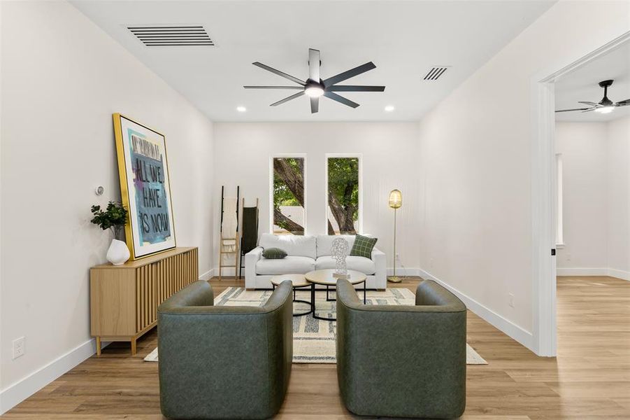 Spacious room featuring wood-finish flooring, light neutral wall tones, and recessed lighting