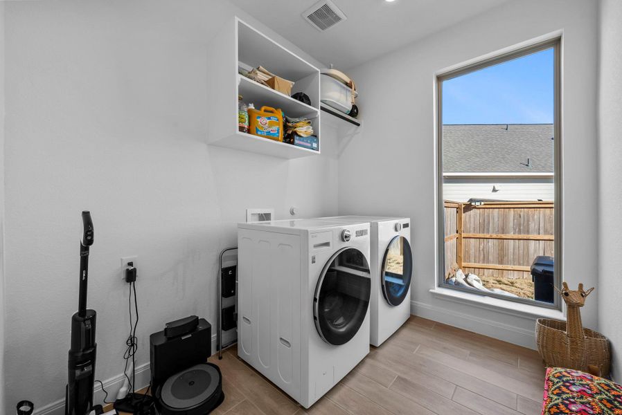 Washroom featuring washing machine and dryer and wood finish floors