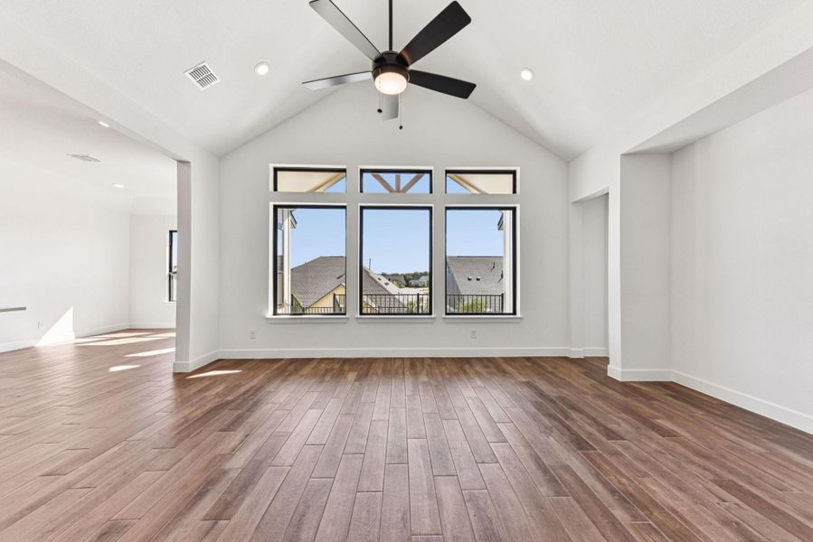 Unfurnished living room featuring vaulted ceiling, dark wood finished floors, ceiling fan, and recessed lighting