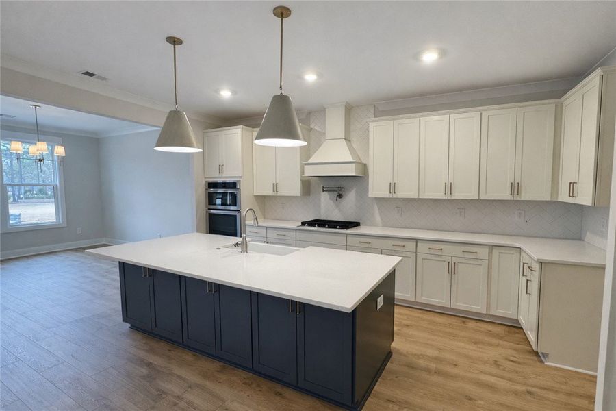 This kitchen showcases a central island and contem
