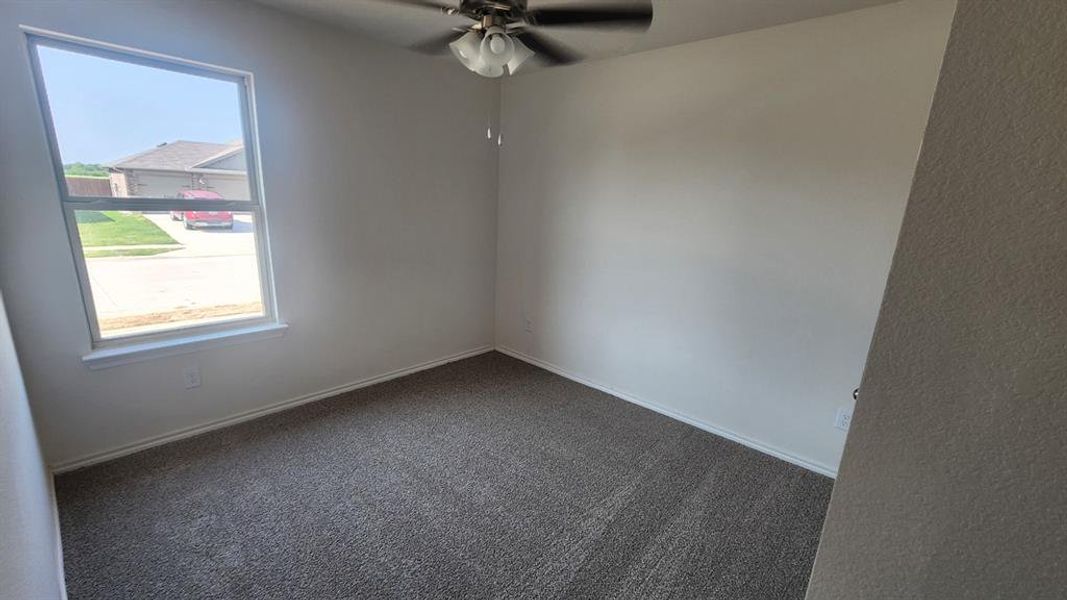 Room featuring neutral-toned walls, gray carpet flooring, and a white-trimmed window Room featuring neutral-toned walls, gray carpet flooring, and a white-trimmed window