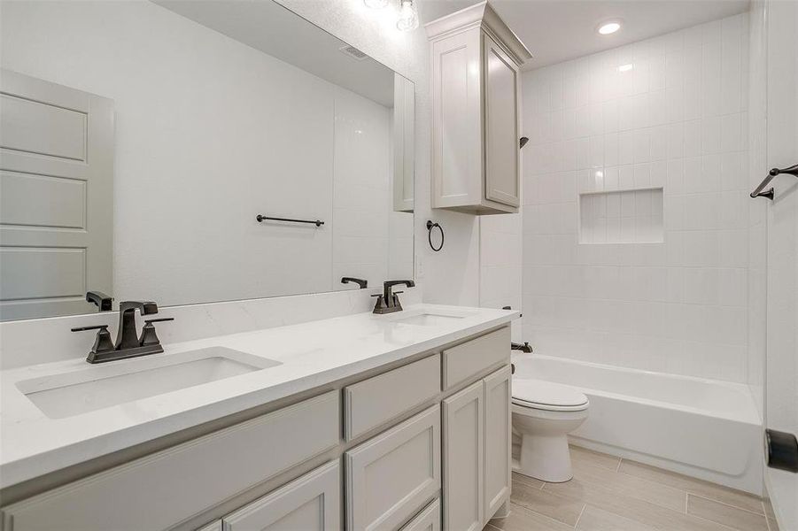 Full bathroom with vanity, toilet, and tiled shower / bath