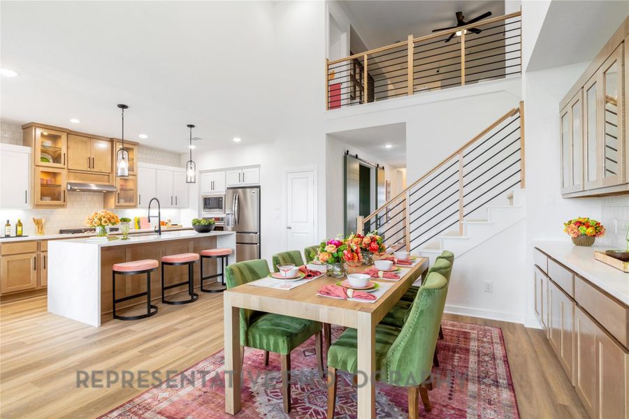Dining room with stairs, light wood-style floors, recessed lighting, a towering ceiling, and a ceiling fan