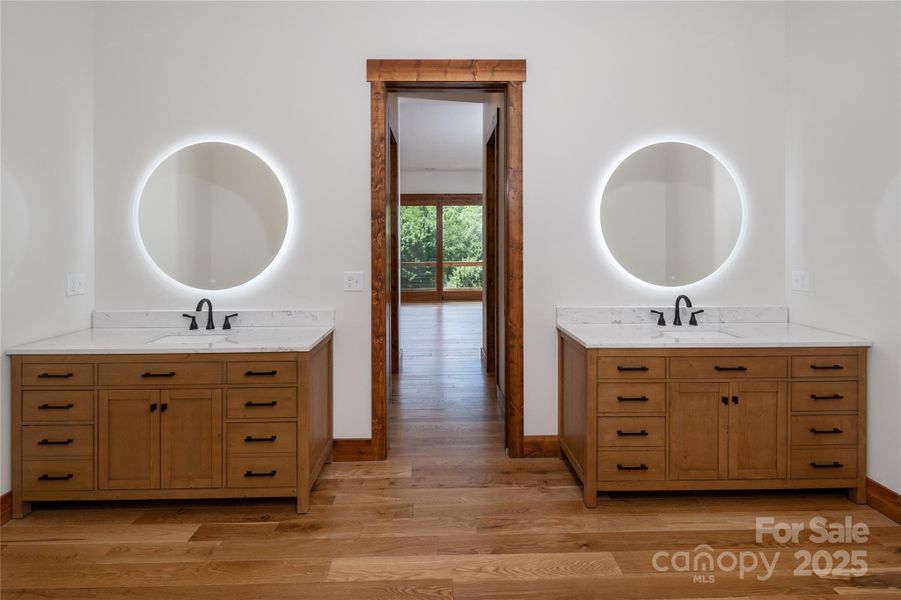 Main floor primary suite with incredible mountain views, access to porch & 2 walk-in closets. Primary bathroom with double vanities & backlit mirrors, soaking bathtub, shower & water closet.