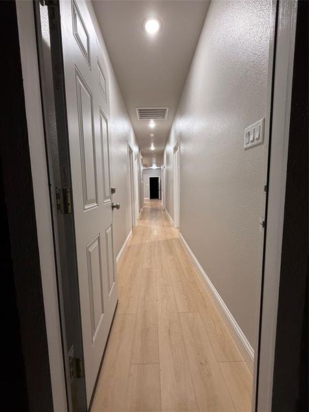 Hall with light wood-style floors and recessed lighting