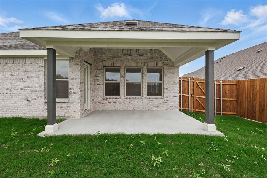 Back of house with fence, a patio, brick siding, a gate, and a lawn Back of house with fence, a patio, brick siding, a gate, and a lawn