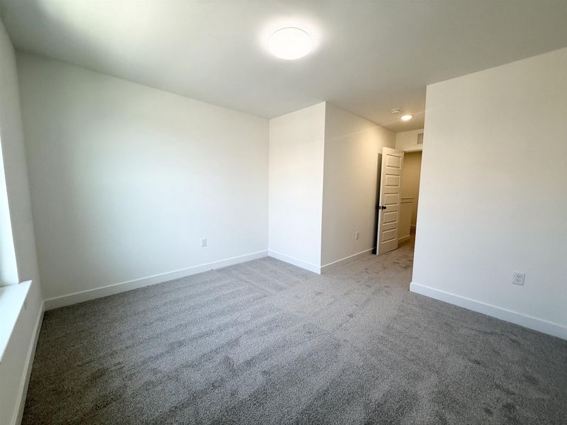 Spare room with light carpet and baseboards